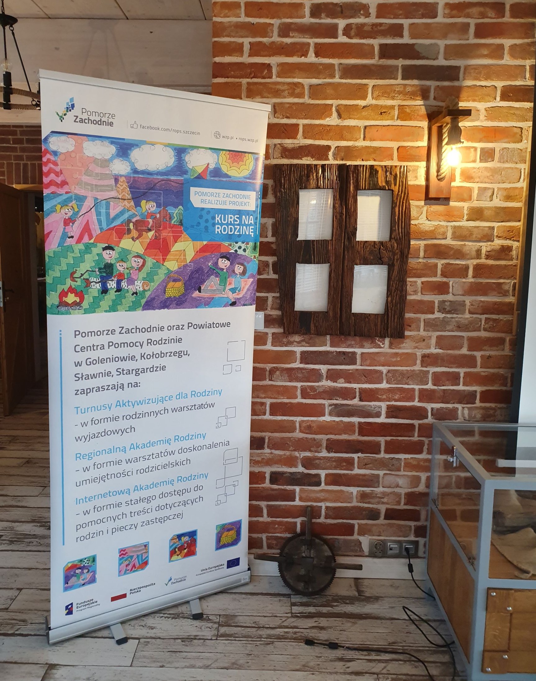 Roll-up projektu Kurs na Rodzinę postawiony w sali, w której odbywa się spotkanie podsumowujące dwa lata działań