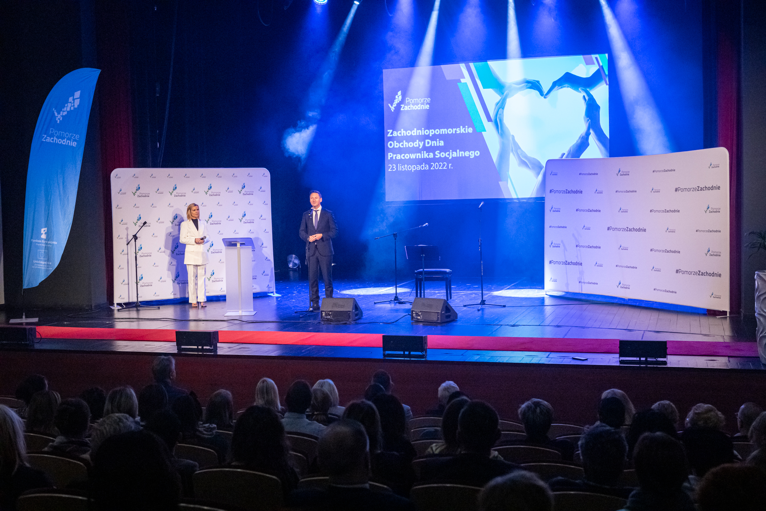 marszałek Olgierd Geblewicz przemawia na scenie, niebieskie tło