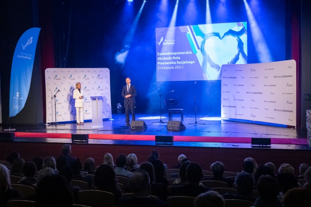 marszałek Olgierd Geblewicz przemawia na scenie, niebieskie tło