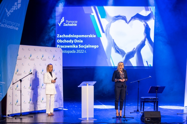 Członkini Zarządu Anna Bańkowska  na scenie, niebieskie tło