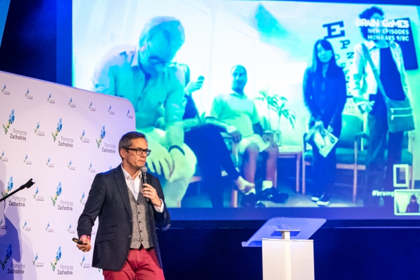 Rafał Rak podczas wykładu, w tle slajd 