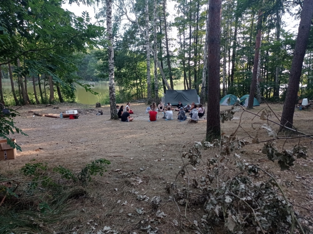 uczestnicy siedząc na ziemi w kręgu prowadzą pierwszy trening mentalny