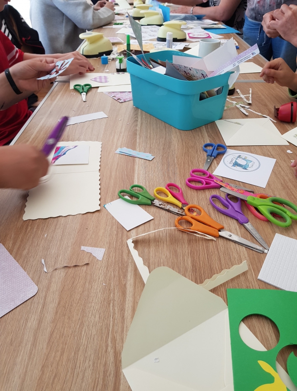 kolorowe kartki, dziurkacze, nożyczki używane przez uczestników do tworzenia kartek