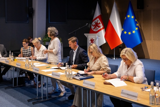 za stołem siedza goście spotkania, Dorota Rybarska-Jarosz z ROPS tłumaczy zasady projektu 