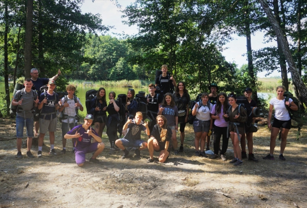 uczestnicy z dobytkiem na plecach wyruszają w pieszą wędrówkę do drugiego punktu obozowania