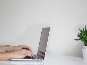 Dłonie na klawiszach laptopa